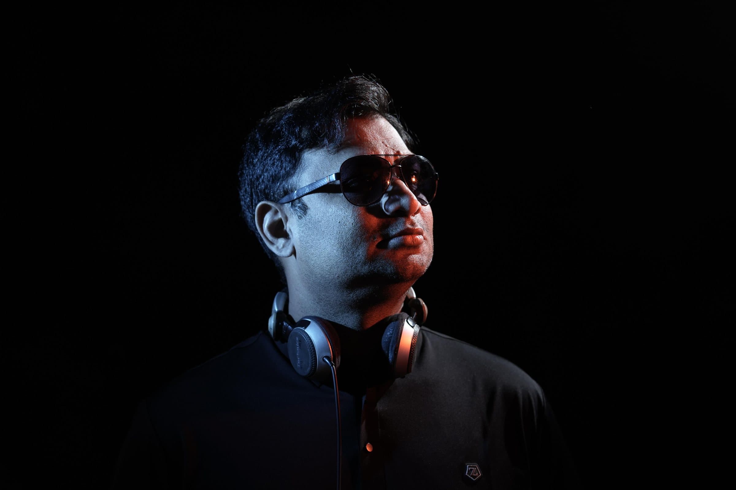 DJ Abdul looking up and away, lit from the side
